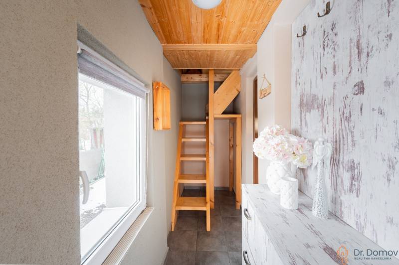 Das Innere der Hütte mit einer Holztreppe und einem Fenster mit Blick nach draußen.