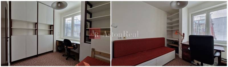 In einem Einfamilienhaus gibt es weiße Schränke, einen Arbeitstisch und ein rotes Sofa.