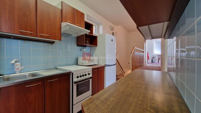 Küche in einem Einfamilienhaus mit Holzdekor, blauen Fliesen und Küchenzeile.