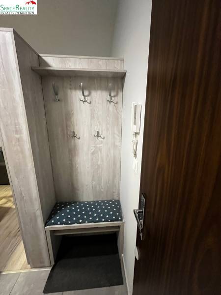 Eingangsflur mit Kleiderhaken und Bank in einer 2-Zimmer-Wohnung.