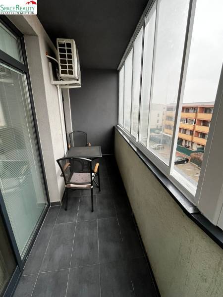 Veranda s presklením 2-izbového bytu na Holubej ulici v Senci s dlažbou a sedením.