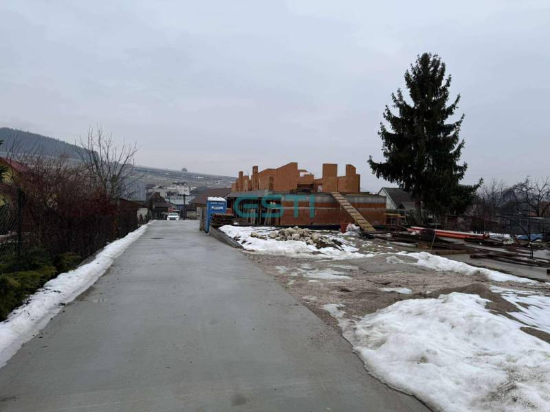 Bauplatz eines Einfamilienhauses in Višňové in der Višňová-Straße mit verschneiter Umgebung und einem Baum.