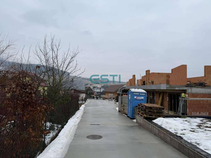 Bau eines Einfamilienhauses in einer verschneiten Straße in Višňové im Rohbauzustand.