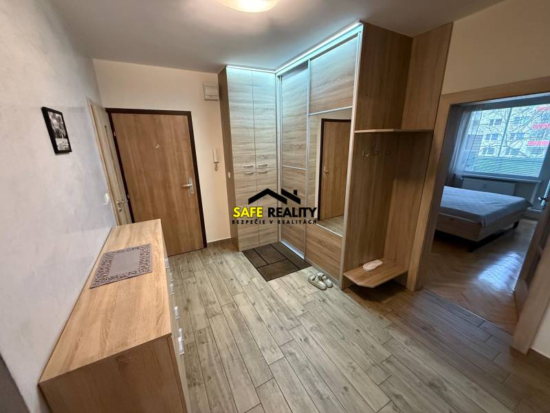 Eingangsbereich in einer 3-Zimmer-Wohnung mit Holzboden, Schrank und Spiegel.