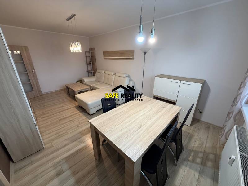 Wohnzimmer mit Holzboden, Sofa und Tisch in einer 3-Zimmer-Wohnung.