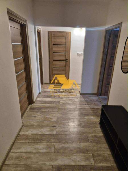 Der Flur in einer 3-Zimmer-Wohnung mit einem Boden in Holzoptik und mehreren Türen.