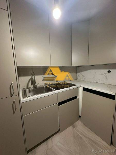 Küche in einer 2-Zimmer-Wohnung mit Marmorplatte und grauen Schränken.