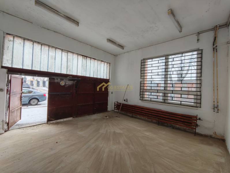 Innenraum einer Garage mit Holzdekorboden und Metalltor.