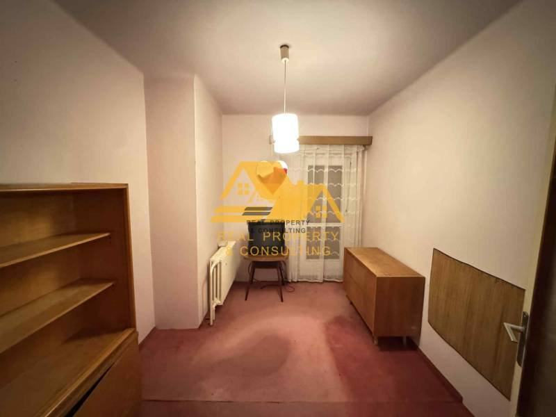 Ein Raum in einem Einfamilienhaus mit Möbeln und Vorhängen, ohne Bodenbelag mit Holzdekor.