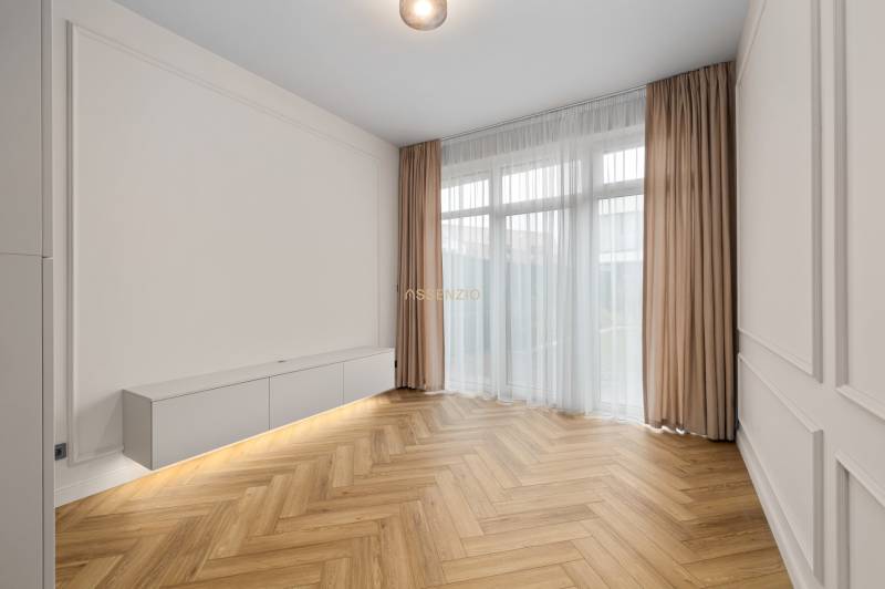 Wohnzimmer in einer 2-Zimmer-Wohnung mit Holzboden und weißen Möbeln.