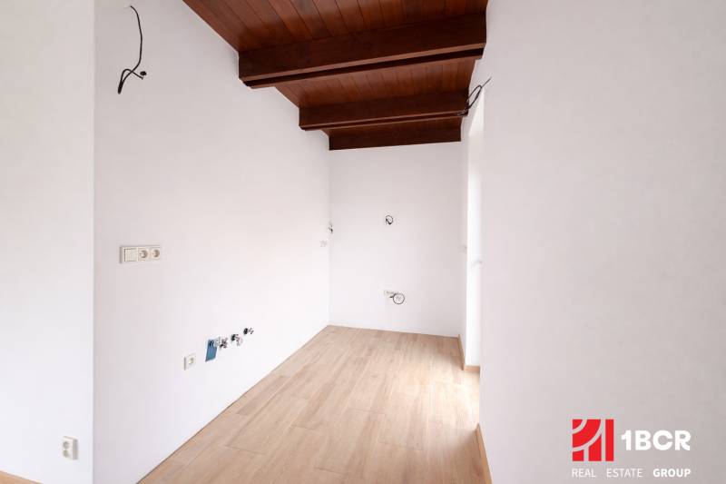 Innenraum eines Einfamilienhauses mit Holzboden und einer Decke mit Holzbalken.