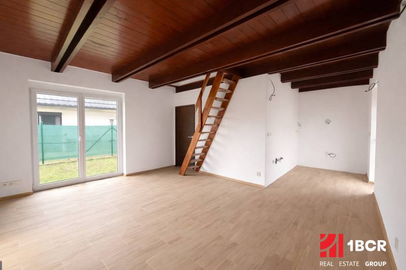 Innenraum eines Einfamilienhauses mit einer Leiter-Treppe und einem Boden in Holzoptik.