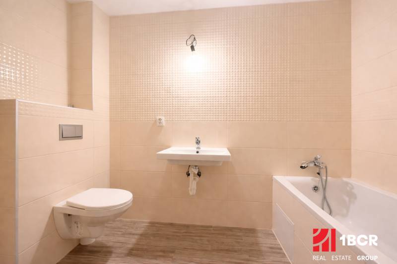 Badezimmer in einem Einfamilienhaus mit Badewanne, Waschbecken und Boden mit Holzdekor.