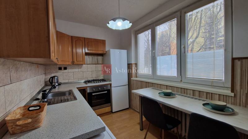 Küche in einer 2-Zimmer-Wohnung mit Geräten und Boden in Holzoptik.