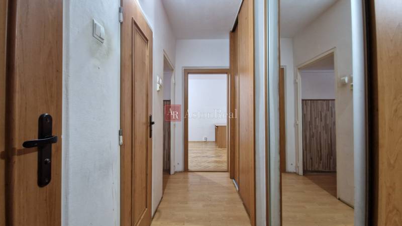 Der Flur einer 2-Zimmer-Wohnung mit Türen und Boden in Holzoptik.