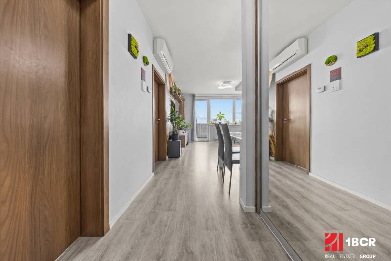 Innenraum einer 2-Zimmer-Wohnung mit Holzboden, Spiegel und Klimaanlage.