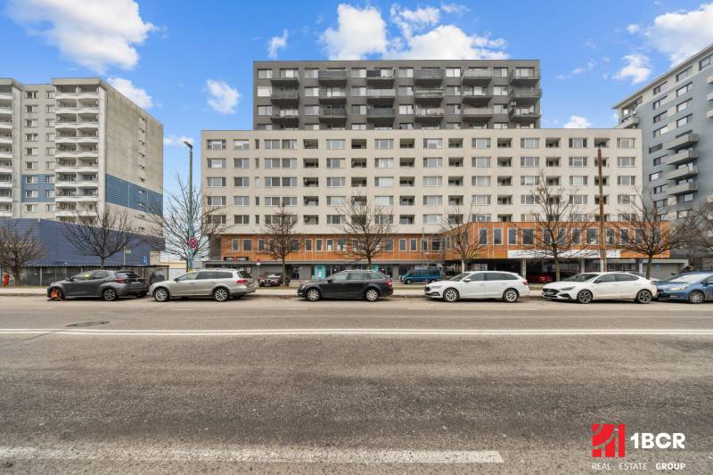 Das Gebäude in der Budatinská-Straße in Bratislava - Petržalka mit davor geparkten Autos.
