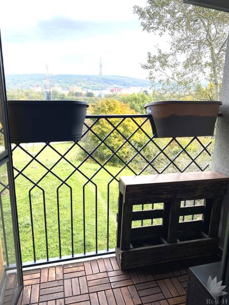 Balkon mit Blick auf Grünflächen und den Stadthorizont, Boden mit Holzdekor.