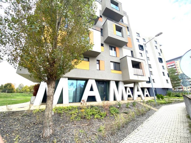 Ein Gebäude mit einer Aufschrift und einem Baum in der Nejedlého-Straße in Bratislava-Dúbravka.