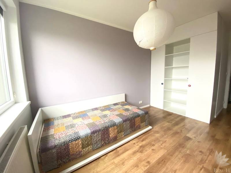 Kinderzimmer in einer 3-Zimmer-Wohnung mit einem Bett und einem Boden in Holzoptik.