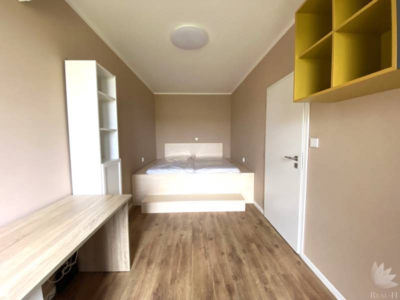 Ein Zimmer in einer 3-Zimmer-Wohnung mit einem Boden in Holzoptik und einem eingebauten Tisch.