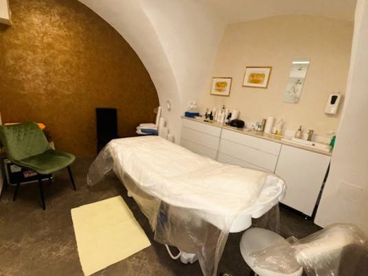 Massagetisch in Geschäftsräumen mit Gewölbedecke, einschließlich Zubehör.