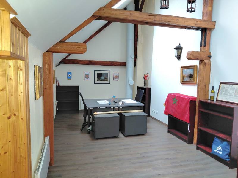 Büros mit Schreibtisch, Holzbalken, Dekoration und Boden mit Holzdekor.