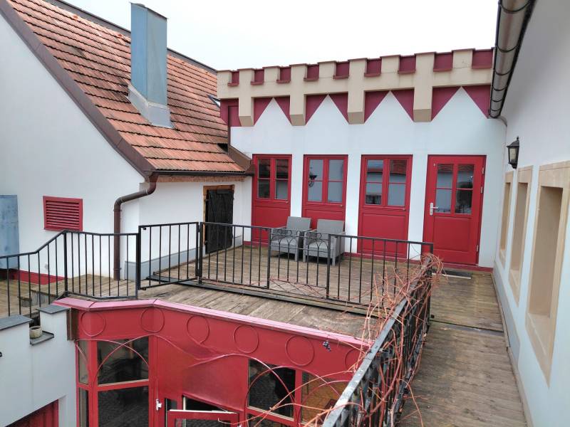 Hof mit Terrasse und roten Türen, umgeben von Architektur in den Büros an der Hauptstraße in Eisenstadt.