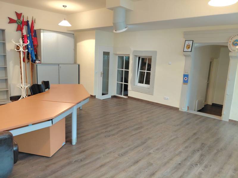 Büros mit Holzboden, Tisch und Schränken.