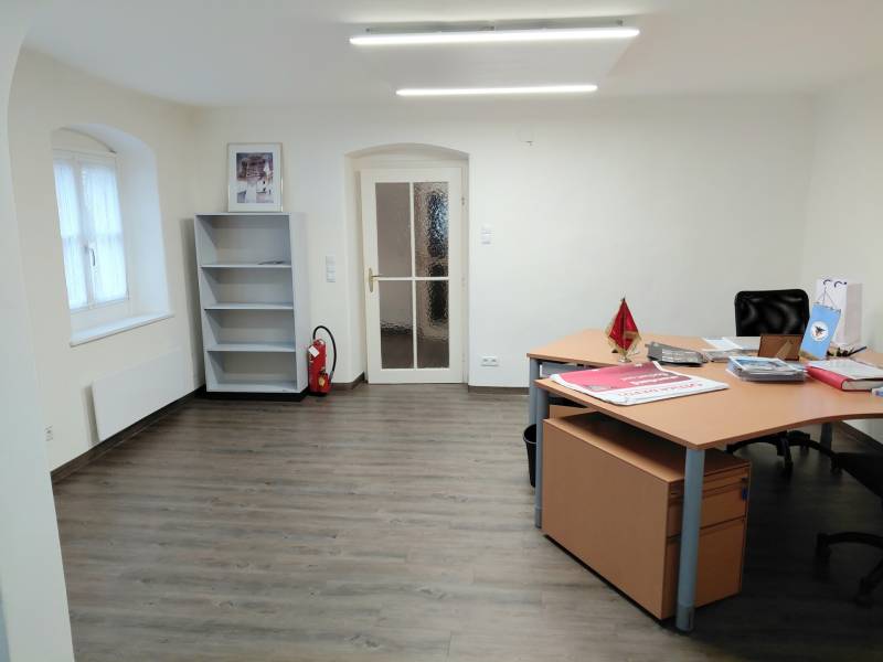 Büros mit Holzboden, Tisch und leerem Regal.