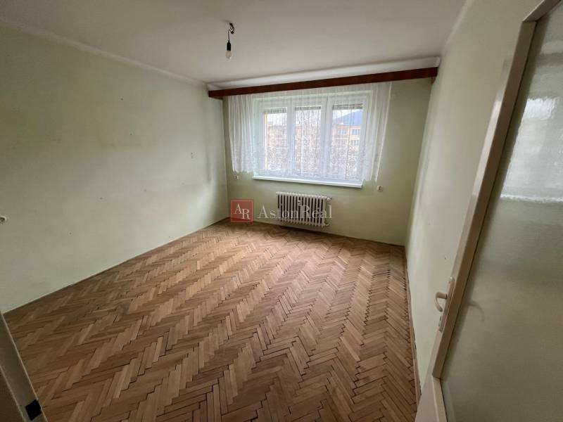 Ein Zimmer in einer 3-Zimmer-Wohnung mit einem Boden in Holzoptik und einem großen Fenster.