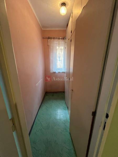 Ein schmaler Raum mit einem Einbauschrank und einem Vorhang in einer 3-Zimmer-Wohnung.