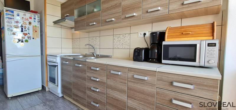 Küche in einer 2-Zimmer-Wohnung mit Holzboden und Geräten.