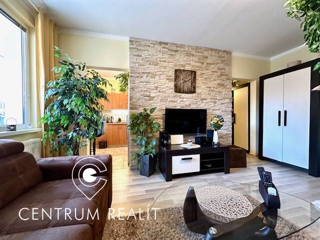 Wohnzimmer in einer Einzimmerwohnung mit Pflanzen und Holzboden.