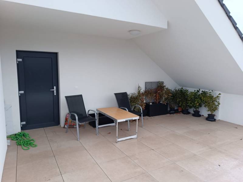 Balkon in einer 2-Zimmer-Wohnung mit Terrasse, Stühlen und Pflanzen.