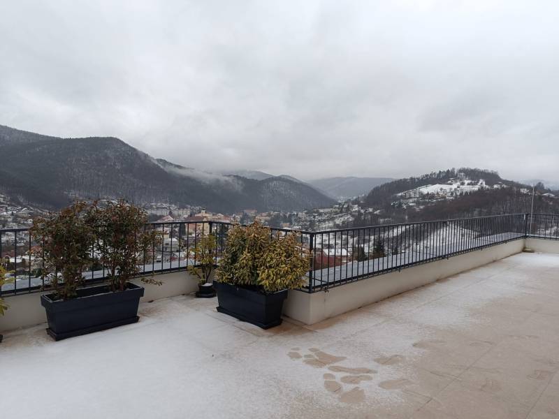 Winterblick auf die verschneiten Hügel in der Stadt Nová Baňa vom Balkon einer 2-Zimmer-Wohnung.
