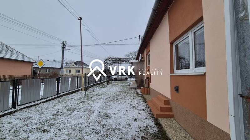 Ein Einfamilienhaus in der Nová-Straße in Veľké Ozorovce mit einem verschneiten Hof und Zaun.
