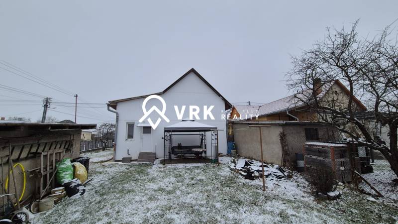 Ein verschneiter Hof mit einem Unterstand hinter einem Einfamilienhaus in der Straße Nová, Veľké Ozorovce.