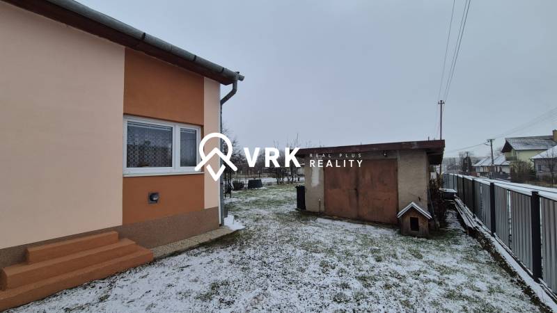 Ein Einfamilienhaus in der Neuen Straße in Veľké Ozorovce mit einem verschneiten Garten und einer Garage.