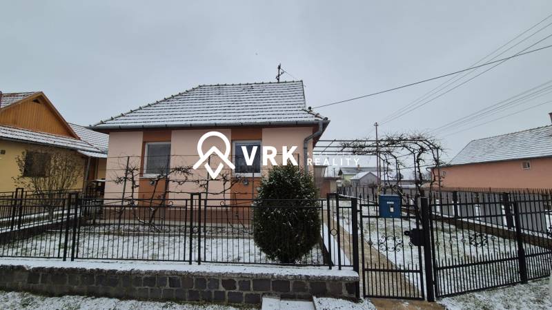 Ein Einfamilienhaus in der Neuen Straße in Veľké Ozorovce mit verschneitem Dach und Garten.