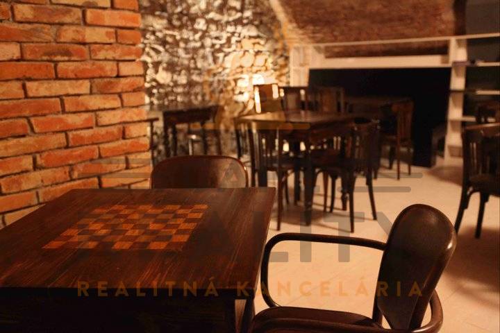 Rustikale Gastrobereiche mit Steinwänden und einem Boden in Holzoptik.