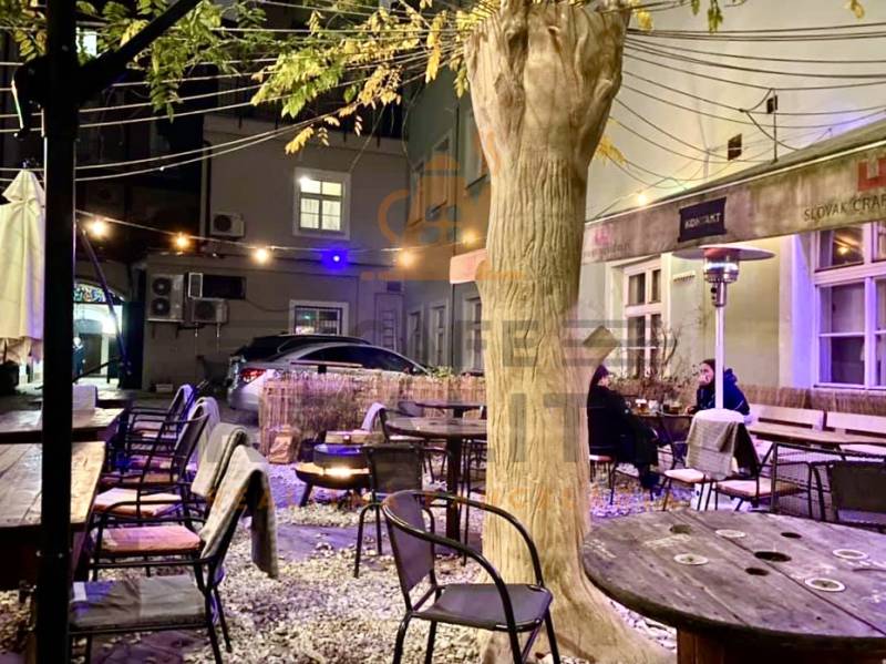 Außenbereich Gastronomiebereiche in der Sedlárska-Straße in Bratislava - Historischer Kern mit Holzsitzgelegenheiten.