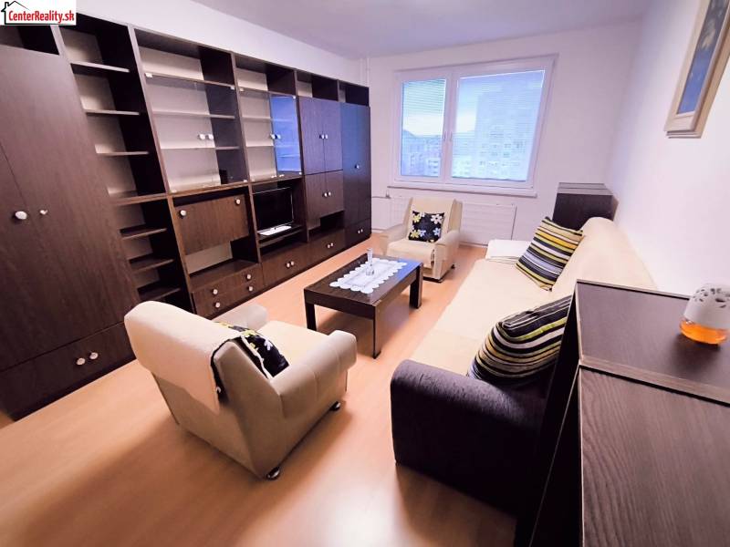 Wohnzimmer in einer 2-Zimmer-Wohnung mit Sofa, Sesseln und Möbelwand.