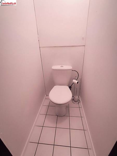Weiße Toiletten mit Fliesenboden in einer 2-Zimmer-Wohnung.