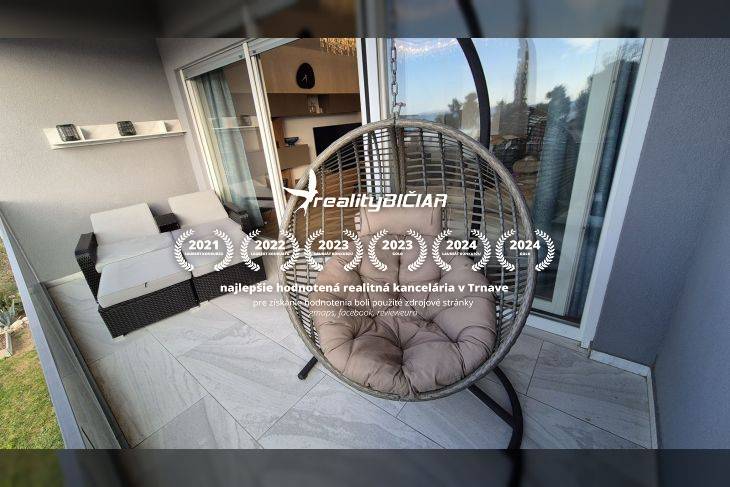 Entspannungsterrasse des Ferienapartments mit rundem Hängesessel und Rattansitzgruppe.