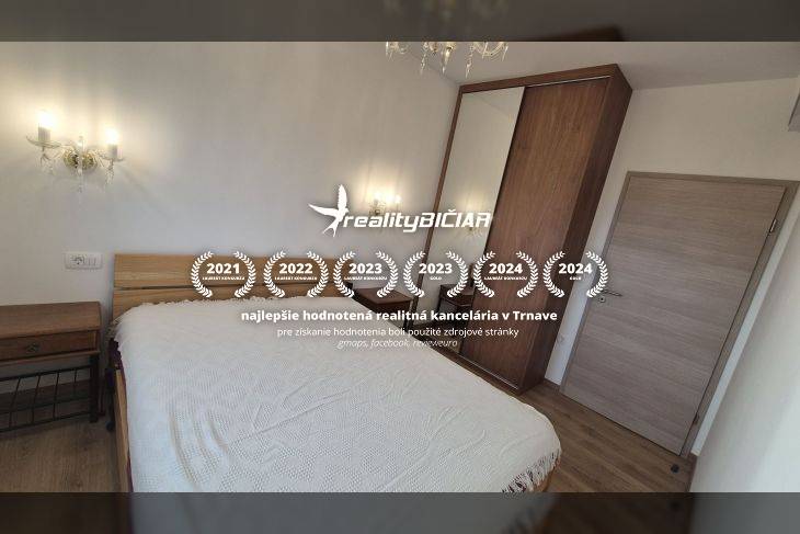 Ferienwohnung mit bequemem Bett und Holzboden, beleuchtet von Wandleuchten.