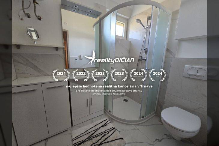 Badezimmer in einer Ferienwohnung mit moderner Duschkabine und weißen Möbeln.