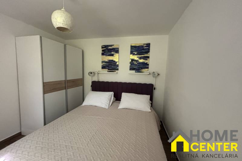 Ein Schlafzimmer in einem Einfamilienhaus mit einem Doppelbett, einem Schrank und Wanddekorationen.