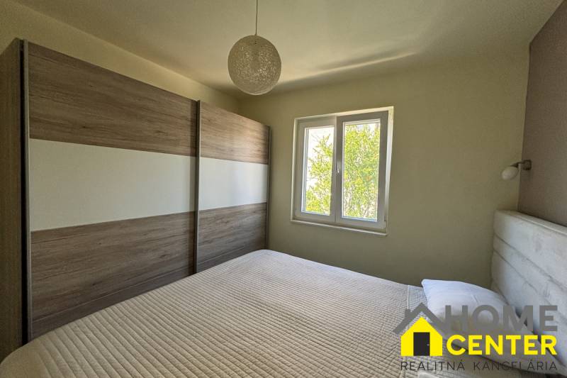 Schlafzimmer in einem Einfamilienhaus mit französischem Fenster und großem Kleiderschrank.