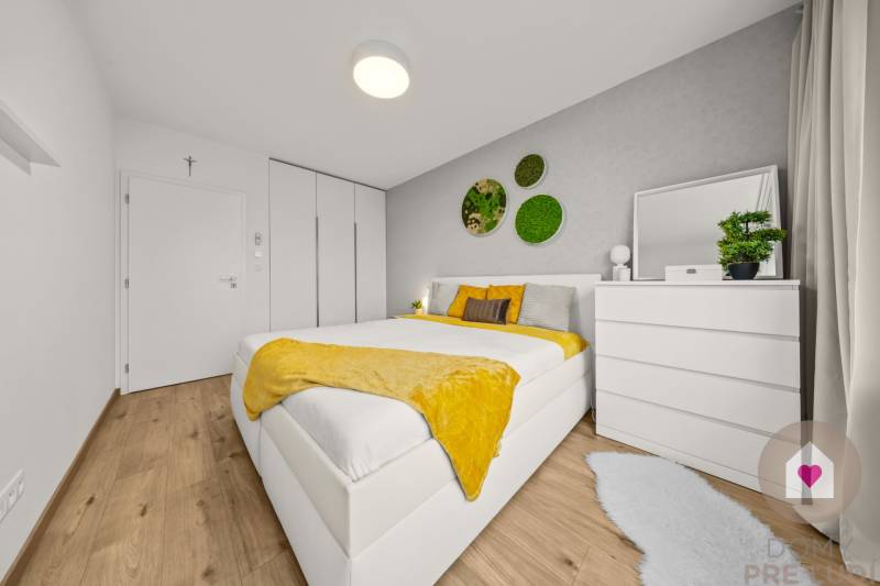 Helles Schlafzimmer mit Bett, weißen Möbeln, Pflanzen und Holzboden in einer 4-Zimmer-Wohnung.